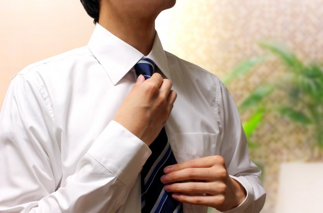 白シャツにネクタイ姿の成人男性